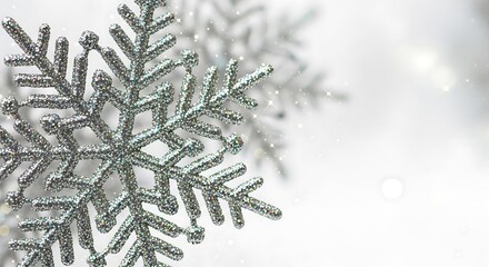 Close up of a sparkling silver snowflake ornament casting a delicate shadow on a soft white background