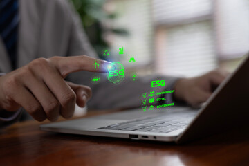Experts interacting with a digital ESG interface on a laptop, focusing on environmental, social, and governance metrics that support sustainable business strategies