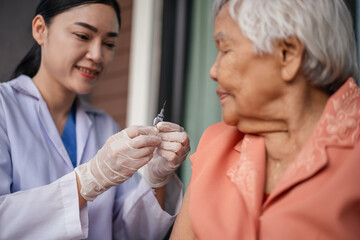 doctor holding syringe and making injection vaccine to senior woman