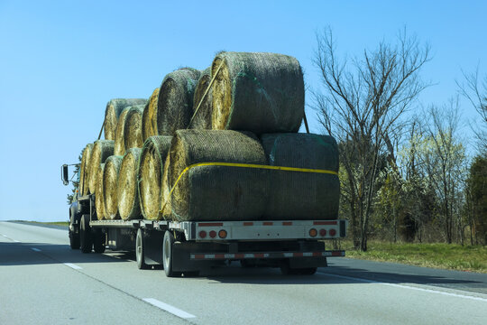 Truck carries multiple hay bales on American rural highway