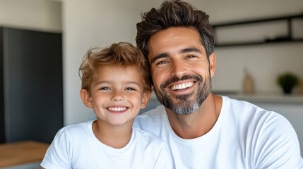 Fototapeta premium Smiling father and son cuddling at home, warm joyful family moment