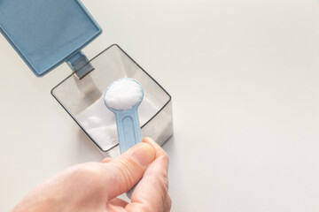 プラスチック容器の中の食塩を小さじですくう