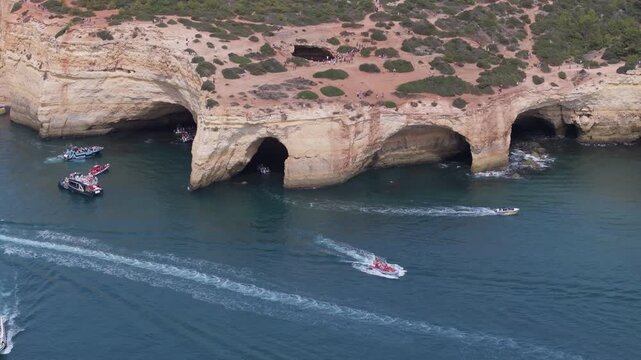 Aerial drone view of the Benagil Sea Cave and Atlantic Ocean coastline in Benagil, Algarve, Portugal, Europe. People standing above the cave