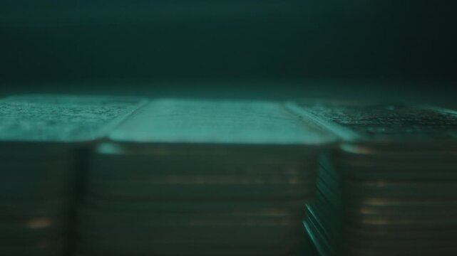 Extreme close focus rack of stacks of silver bars in a vault with blue light