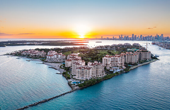 Aerial view of Fisher Island Miami at sunset with city skyline.