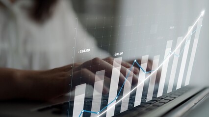 Professional hands typing on a laptop amidst financial graphs, showcasing data analysis and growth trends in a modern office setting. Perfect for finance themes. Copula