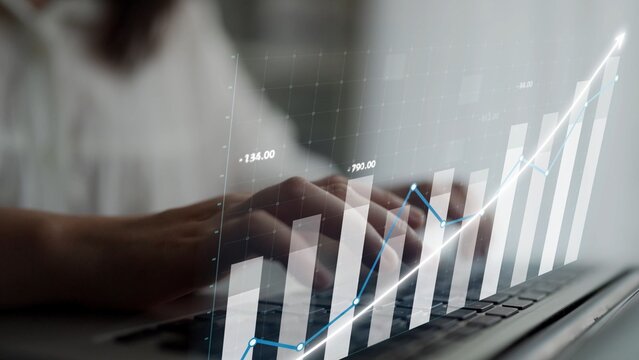 Professional hands typing on a laptop amidst financial graphs, showcasing data analysis and growth trends in a modern office setting. Perfect for finance themes. Copula - Powered by Adobe