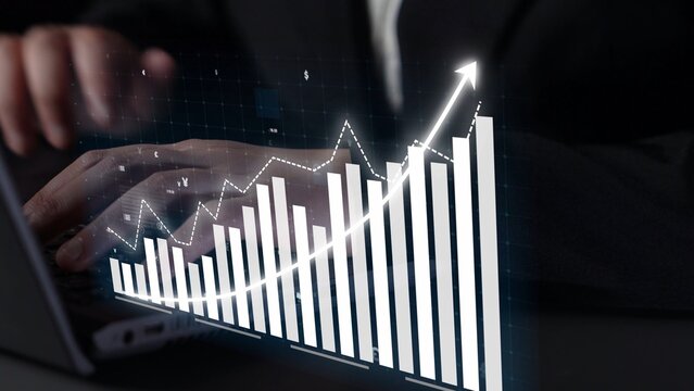 A businessman works on a laptop while analyzing financial growth trends through digital graphs and charts, showcasing modern office productivity and technology. Copula - Powered by Adobe