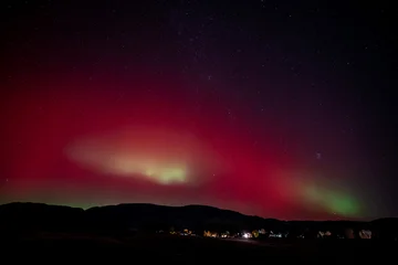 Fototapete Rund Bordeaux Red and green Aurora Borealis - Northern Lights - display over town of New Castle, Colorado of 11-11-2025.  © Francisco