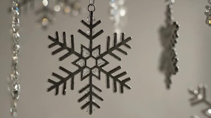 Close-up of hanging snowflake ornaments with bokeh lights in the background. - Powered by Adobe