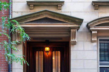 Elegant stone entrance with classical pediment and glowing lantern light in Beacon Hill, Boston, Massachusetts, USA