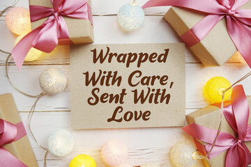 Wrapped With Care, Sent With Love text with gift present and LED cotton balls decorate on wooden background