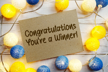 Congratulations You're a Winner! text with LED cotton balls decorate on wooden background