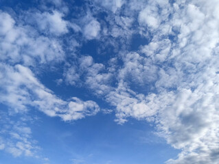 Obraz premium Blue sky with scattered white clouds on a sunny day with a clear atmosphere and natural lighting.