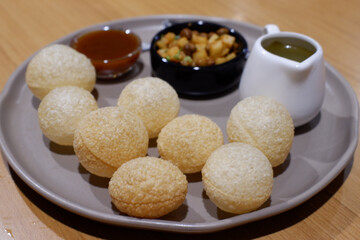 Delicious Indian street food pani puri, also known as golgappa, presented as crispy, fried snack or appetizer. Traditional meal brings enjoyment with savory, spicy, and tangy flavors