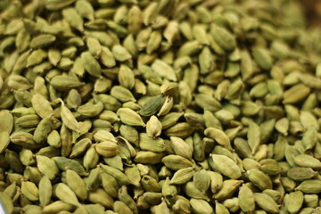Green cardamom pods texture background showing whole elaichi spice seeds natural pattern closeup