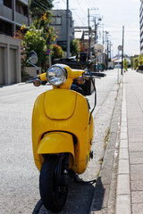 道路に止まっている宅配用の黄色いオートバイ