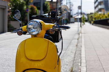 道路に止まっている宅配用の黄色いオートバイ
