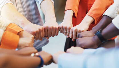 Business people, fist bump and huddle with diversity for unity, solidarity or mission. Group, employees or colleagues with hands together, support or trust for community circle, inclusion or equality