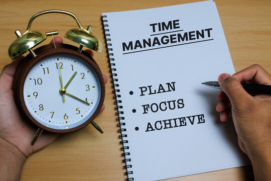 A classic alarm clock held in hand next to a spiral notebook with the words PLAN, FOCUS, and ACHIEVE, symbolizing time management, productivity, goal setting, and effective planning in daily work - Powered by Adobe