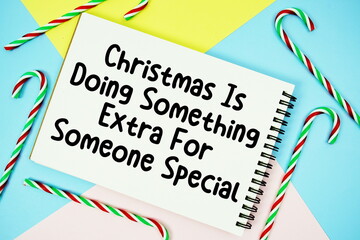 Christmas is the Spirit of Giving without a thought of Getting message of season holidays written on notepad with candy cane decoration on pastel background