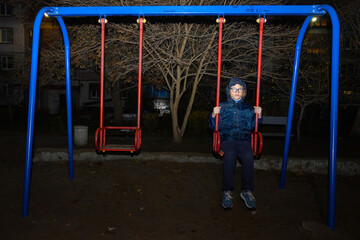 lonely boy on playground in the evening outdoors