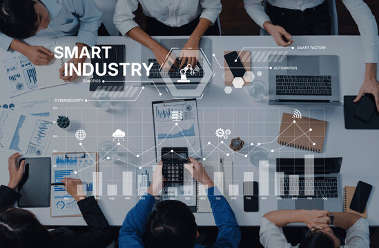 A modern business team collaborates over digital tools and data presentations in a smart industry setting, fostering innovation and effective decision-making. Trope