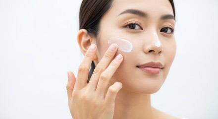 Woman applying cream to cheek