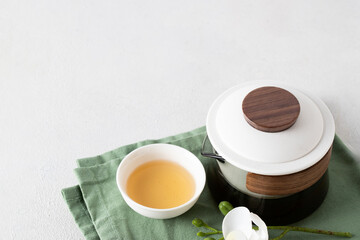 Elegant tea ceremony moment with herbal infusion served in white bowls, wood texture and orchid bloom adding natural beauty and tranquil atmosphere.