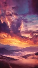 Fototapeta premium Vibrant sunrise over misty mountain peaks and dramatic clouds