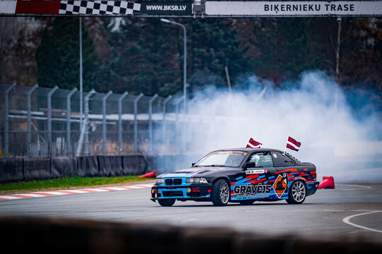 Latvia, Riga 03-05.10.2025. FIA Drifting cup. A car with a flag on top of it driving on a track