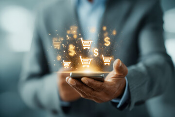 Businessman holding smartphone with glowing shopping cart and dollar sign icons symbolizing digital commerce and online financial transactions concept