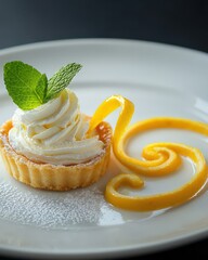A dessert plate featuring a lemon tart with a swirl of whipped cream and a sprig of mint