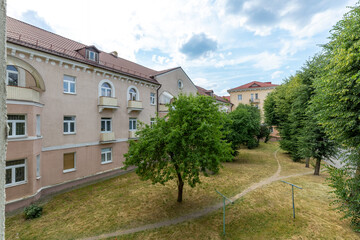 Courtyard View with Green Trees and Historic Buildings