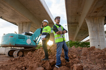 Construction engineers communicate with radios at road construction site. Inspect structure, supervise new infrastructure work, civil engineer outdoor at Thailand Asia construction site.
