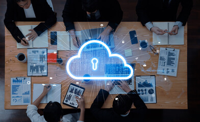 A diverse team engages in a business meeting focused on data security, utilizing cloud computing visuals while analyzing charts and reports at a modern workspace table. Trope