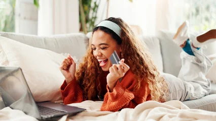 Fototapeten Pony Credit card, laptop and celebration with woman on couch for online shopping, ecommerce and sale. Payment, banking website and person excited in lounge of home for deal, transaction or subscription  © peopleimages.com