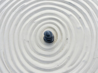 Calm zen garden with raked sand ripples and a stack of peaceful balancing stones