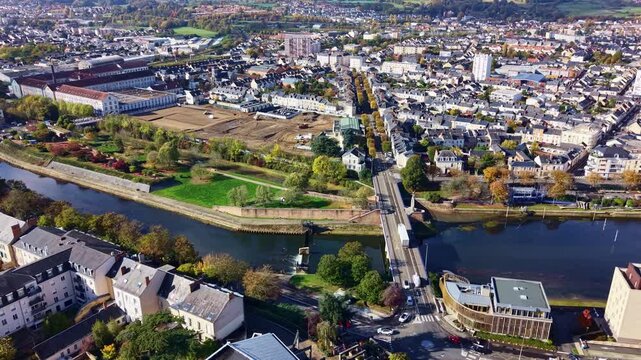 Drone panning cityscape showing European Le Mans town with Sarthe River bends and dense residential blocks, France