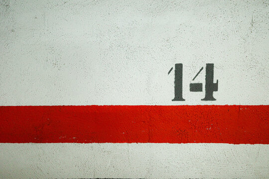 Parking lot wall with red stripe and number 14 marking - Powered by Adobe