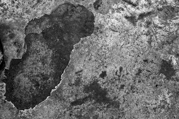 Aged black and gray stone texture with organic stains, cracked patterns and rugged natural surface background