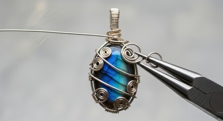 Intricate blue stone wire wrap jewelry with silver accents in progress