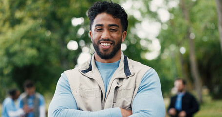 Arms crossed, volunteer and portrait with man in park for donation, community service and ngo project. Nonprofit pride, grocery distribution and food drive with person outdoor for outreach program