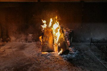 A freshly lit fire, with some wooden sticks burning to make embers for dinner.