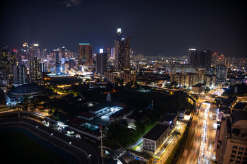 Obraz premium Long Exposure Aerial Night View of a Metropolis Skyline with Blurring Car Light Trails on the Busy Highway