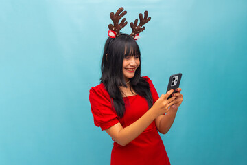 Happy woman with antlers celebrates success holding smartphone Ideal for Christmas sales and...