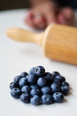 Blueberry pie ingredients arranged artistically fresh blueberries, flour, butter, and rolling pin. An artistic flat lay composition of ingredients for a blueberry pie. Scattered fresh, ripe