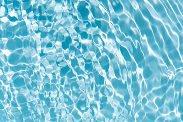 Blue water with ripples on the surface. Defocus blurred transparent blue colored clear calm water surface texture with splashes and bubbles. Water waves with shining pattern texture background.