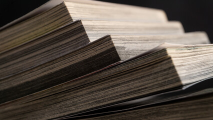 Sharp close-up of angled book pages in soft focus, revealing intricate texture and natural wear, ideal for backgrounds related to reading, literature, or research.