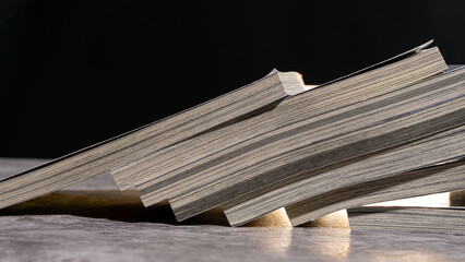 Side detail of books arranged diagonally, emphasizing rhythmic lines of page edges and warm highlights, suitable for creativity, study, or publishing concepts.